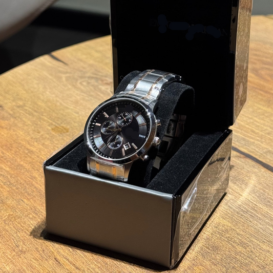 Watch in a black box on a wooden surface with a blurred background