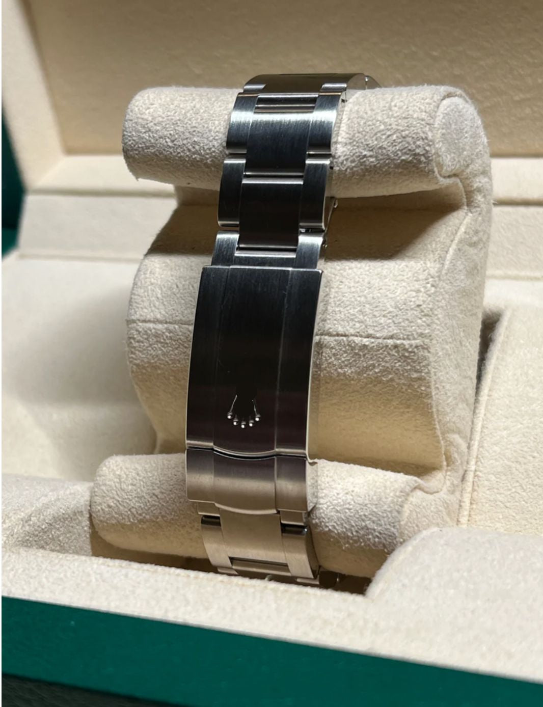 Silver watch band on a display stand with a visible brand logo.