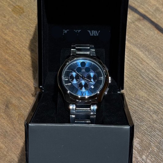 Silver Emporio Armani watch in a black box on a wooden surface