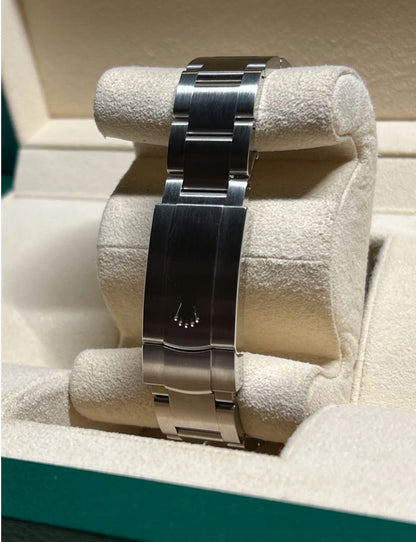Silver watch band on a display stand with a visible brand logo.